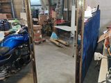 a large mirror in the middle of a room with a motorcycle parked in front of it