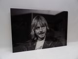 photographie en noir et blanc d'un homme aux cheveux longs portant une veste en cuir