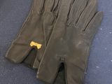 pair of black leather gloves sitting on top of a blue carpet