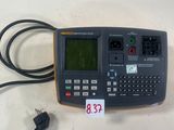 un gros plan d'une calculatrice posée sur une table à côté d'un chargeur