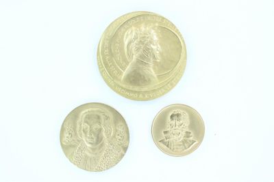 trois types différents de pièces d'or sur une surface blanche