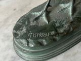 a statue of a bird sitting on top of a rock