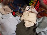 un tas de vêtements dans une valise, avec une personne en train de prendre une photo