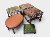 quatre tabourets rembourrés de couleurs différentes et un repose-pieds