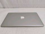 a silver apple laptop sitting on a white surface