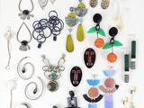 many different pieces of jewelry displayed on a white surface