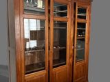 a large wooden cabinet with glass doors on it
