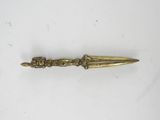 an antique brass dagger with a long blade on a white surface