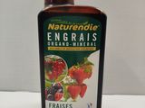 une image représentant une bouteille remplie d'un liquide contenant des fraises et des fraises