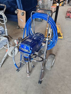 a picture of a blue airless paint sprayer in a garage