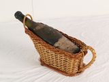 un panier en osier contenant une bouteille de vin
