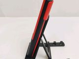 a red and black device on a stand on a white surface