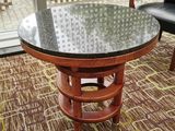 une table avec un plateau en verre posée sur un sol recouvert de moquette