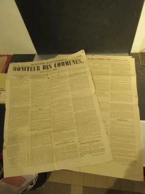 deux journaux posés sur un bureau, à côté d'une lampe
