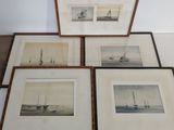 quatre photos encadrées représentant des bateaux, posées sur une table avec un fond blanc
