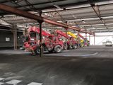 de nombreux camions rouges et jaunes garés dans un garage