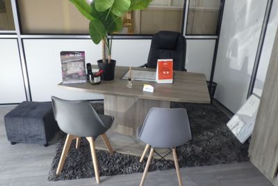 un bureau avec deux chaises et une plante dans un coin