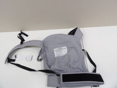 grey and black baby carrier on a white table with a tag on it