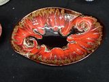 a red and brown plate with a fish design on it