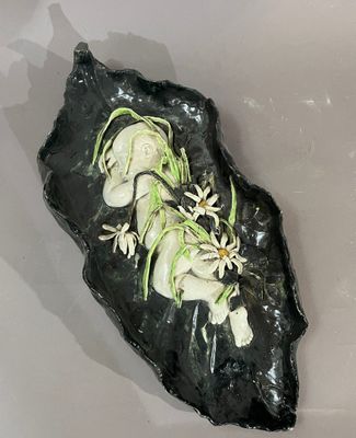 un morceau de roche noire parsemé de fleurs blanches