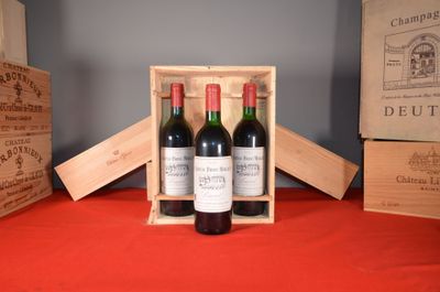 three bottles of wine in a wooden box on a table