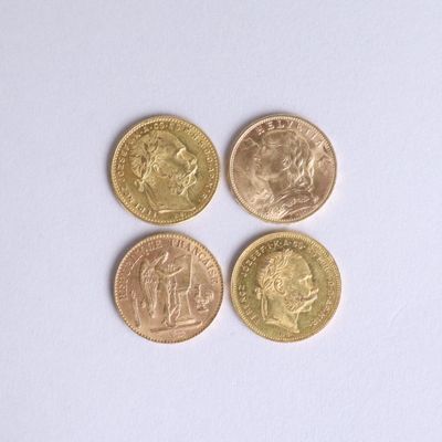 four different british coins sitting on top of a white surface