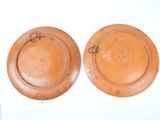 two brown plates sitting on top of a white table next to each other