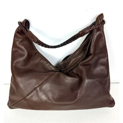 sac à main en cuir marron avec des anses tressées sur un fond blanc