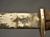 close up of a knife with a rusted handle on a gray background