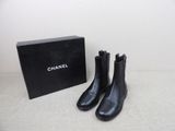 une paire de bottes noires posée à côté d'une boîte noire