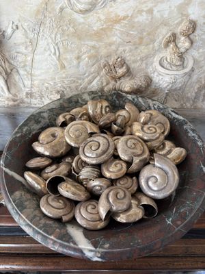 a bowl of snails sitting on a table in front of a wall