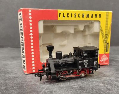 un petit train en jouet posé devant une boîte