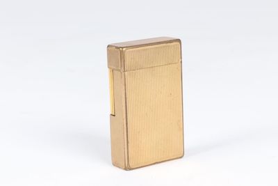 a gold lighter sitting on top of a white surface