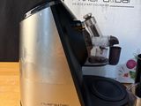 a silver and black blender sitting on a table next to a toothbrush