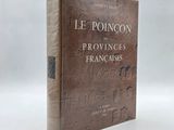 un vieux livre posé sur une table blanche à côté d'un mur blanc
