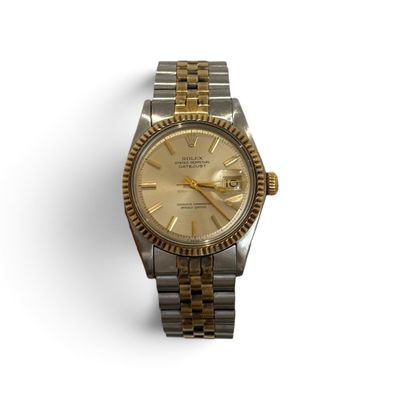 an image of a gold and silver wrist watch on a white surface