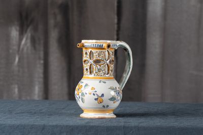 un petit vase posé sur une table recouverte d'un linge bleu