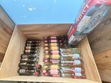 a wooden box filled with bottles of wine and a can of soda
