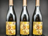 trois bouteilles de vin posées sur une table en bois