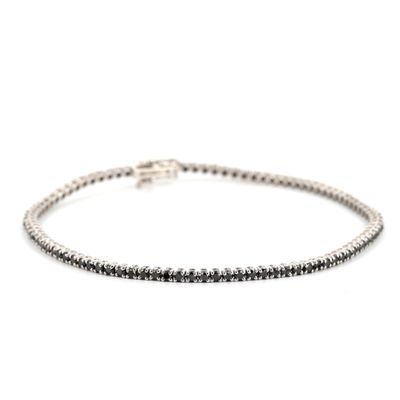 un bracelet tennis en diamants noirs et blancs sur fond blanc
