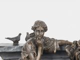 a bronze statue of a boy and a girl sitting on a bench
