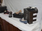 several pairs of shoes are sitting on a table with boxes