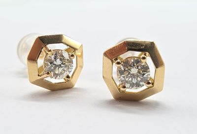 une paire de boucles d'oreilles en diamant sur une surface blanche