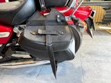 a red motorcycle with a black bag on the back of it