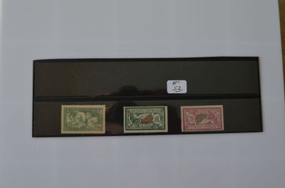trois timbres différents posés sur une feuille de papier posée sur une table