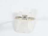 a close up of a diamond ring on a white surface