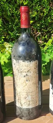three bottles of wine are lined up on a wooden table