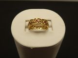 a close up of a gold ring with a red stone in it