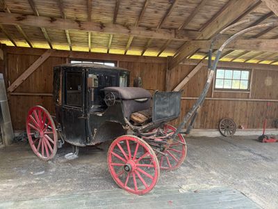un cheval et une calèche dans le garage d'une grange