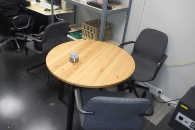 une petite table sur laquelle se trouve une tasse, dans une pièce